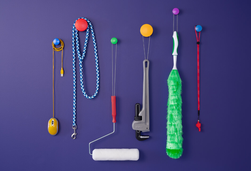 Computer mouse, dog leash, paint roller and various tools suspended from utility hooks