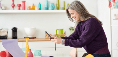 A woman takes a picture of her merchandise with her phone